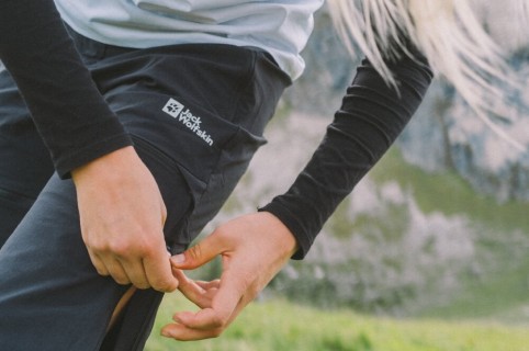 Nahaufnahme einer Frau, die ihre Outdoor-Hose anpasst.