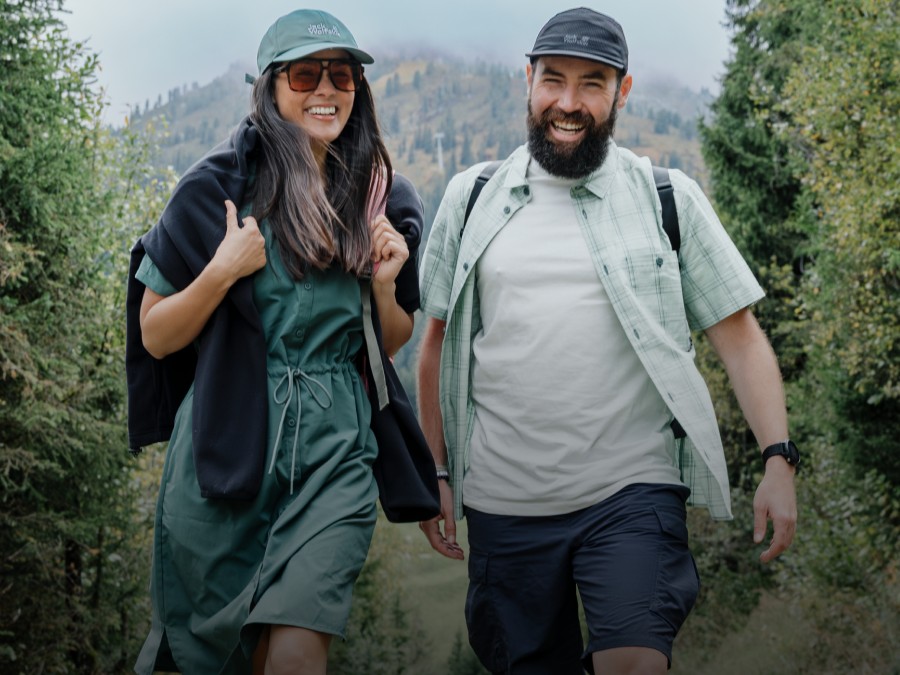 Drei junge Erwachsene in sportlicher Outdoorbekleidung halten sich in einer bergigen&nbsp;Landschaft&nbsp;auf