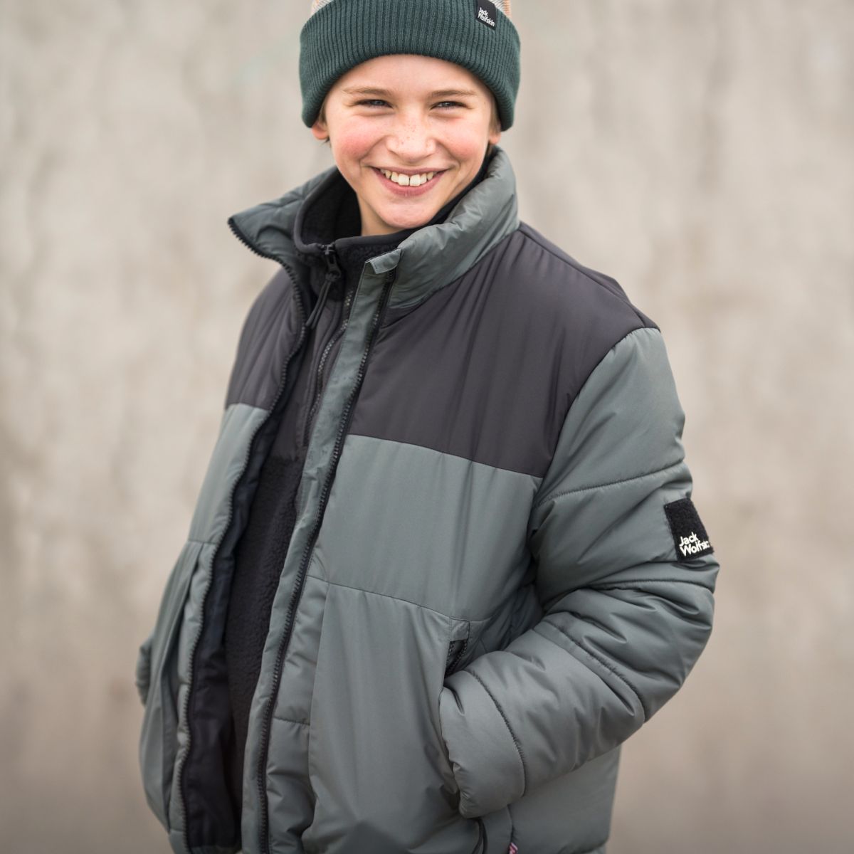 Junge mit Winterjacke lachend