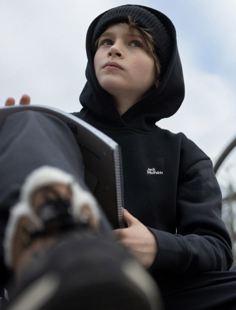 Junge mit Schreibblock und Hoodie