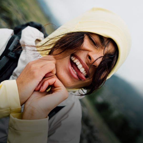 Frau und Mann in sommerlicher Outdoor-Kleidung klettern einen Felsen hinauf