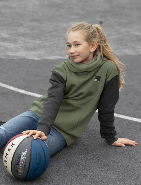 Mädchen sitzt auf dem Boden mit Basketball