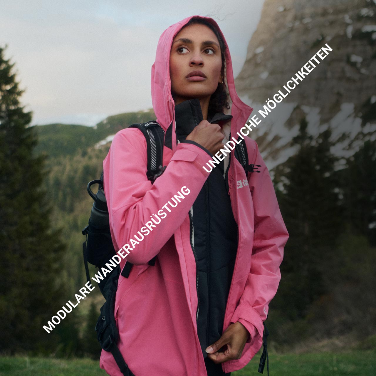 Eine Person in einer rosafarbenen Jacke steht in einem bergigen Waldgebiet und schaut nachdenklich. Der Text lautet: „Modulare Wanderausrüstung" und „Unendliche Möglichkeiten“