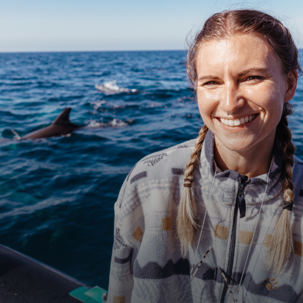 Margarita auf einem Boot mit Delfinen im Hintergrund
