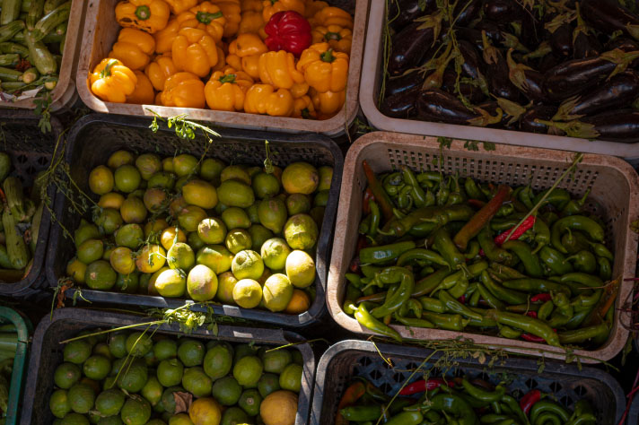 Paprika, Gurken, Limetten und Auberginen in großen Kisten