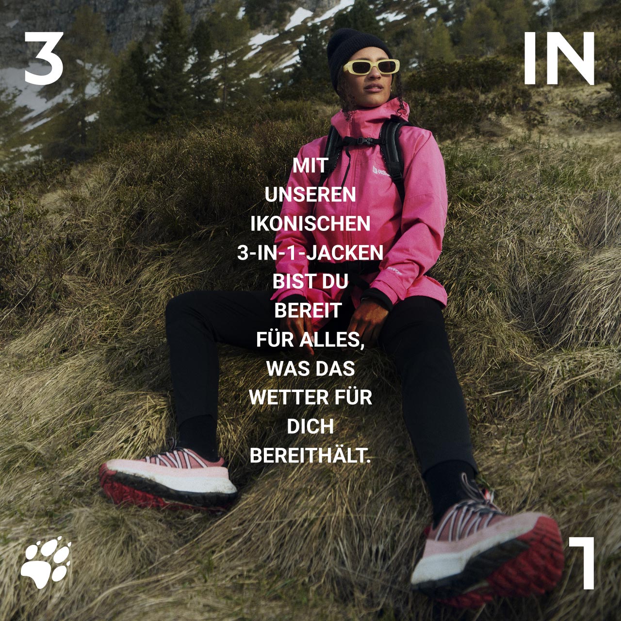 Person in rosa Jacke und Mütze auf einem grasbewachsenen Hang sitzend, mit Sonnenbrille und Wanderschuhen. Text: „Mit unseren ikonischen 3-in-1-Jacken bist du bereit für alles, was das Wetter für dich bereithält.“