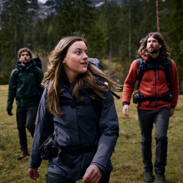Vier Wanderer laufen durch einen Wald