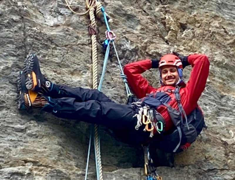 Michel beim Klettern an einer Felswand hängend